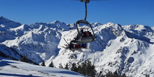 Télécabine transportant des skieurs au-dessus de montagnes enneigées