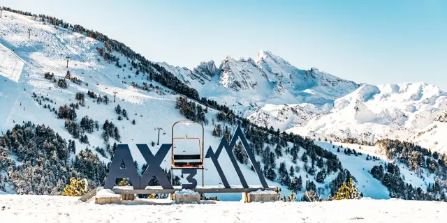 Piste de ski avec le logo AX3 et une remontée mécanique