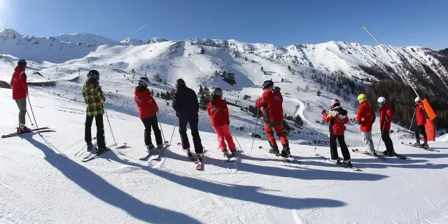 Un groupe de personnes en cours de ski sur une piste enneigée