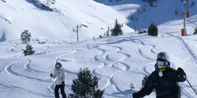 Deux skieurs sur une piste de ski en montagne