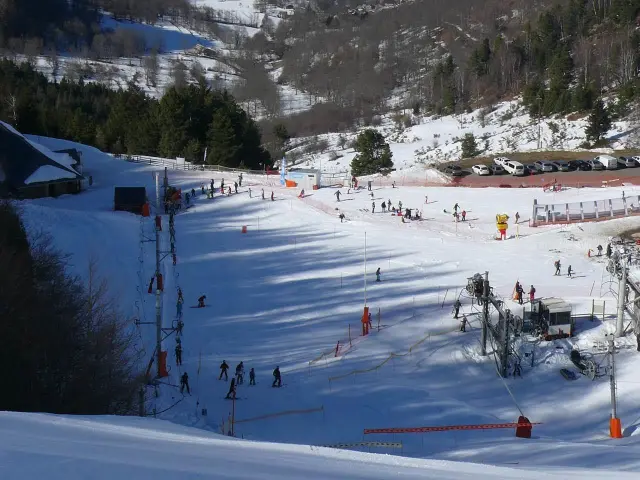 Pista de esquí con esquiadores y principiantes en cintas transportadoras