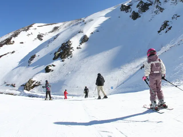 Groupe de skieurs sur une pente enneigée avec un ciel bleu