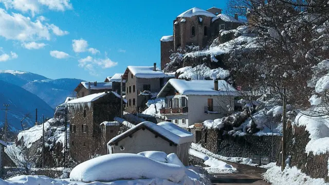 Snow-covered mountain village with snow-covered houses and trees