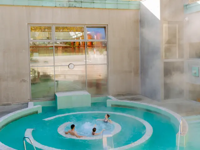 Personas relajándose en un baño termal al aire libre