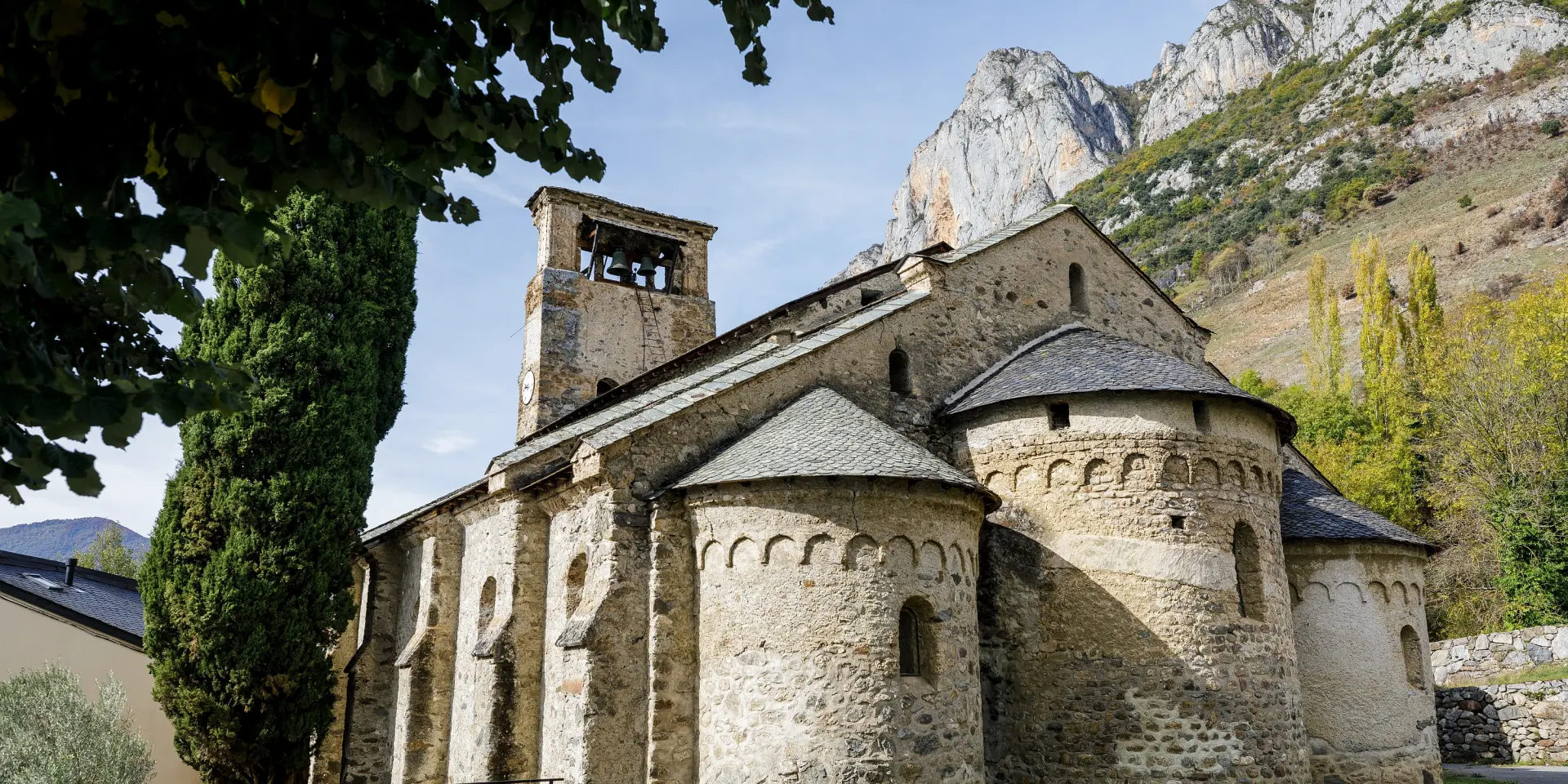 Abbaye médiévale en pierre avec une tour et des arcs romans