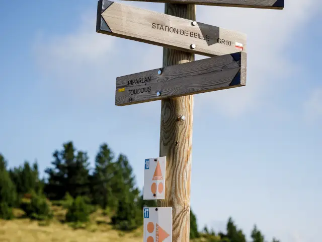Panneau directionnel en bois avec plusieurs flèches indiquant des directions