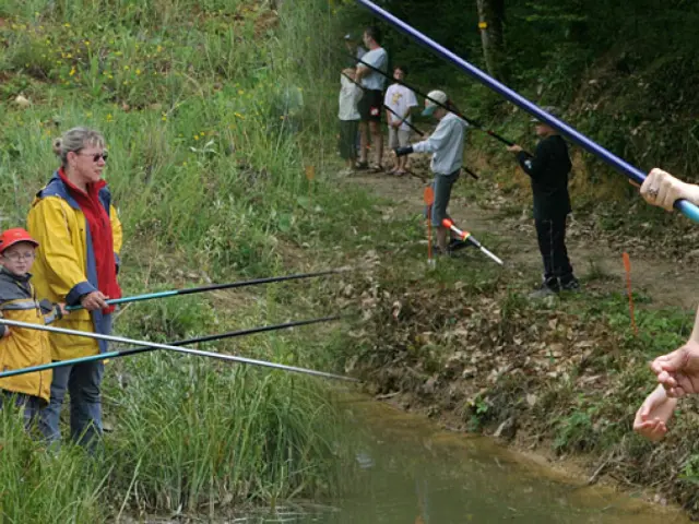 Un groupe de personnes pêchant ensemble dans un ruisseau