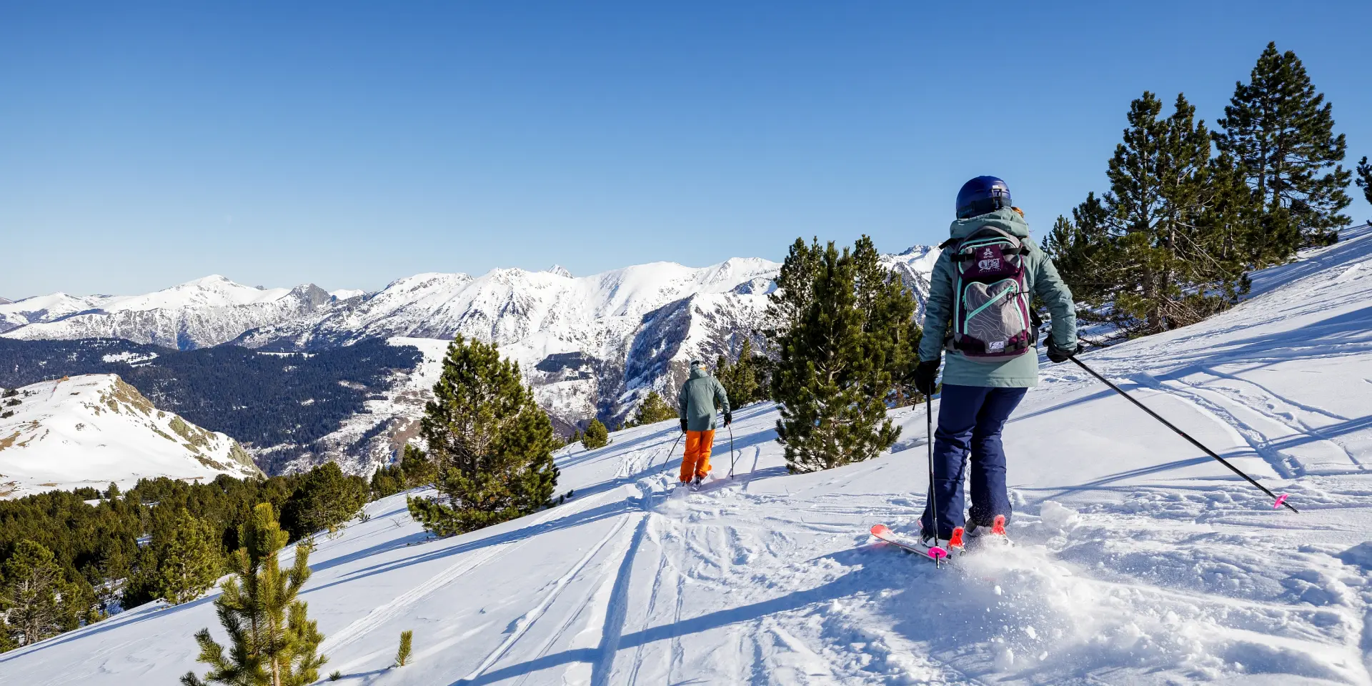 Deux personnes faisant du ski de randonnée dans un paysage enneigé
