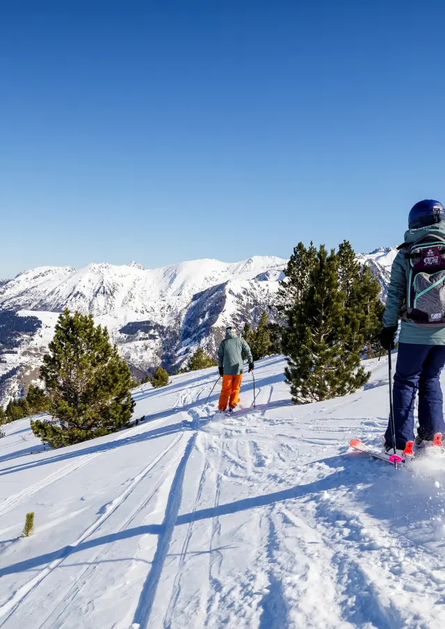 Deux personnes faisant du ski de randonnée dans un paysage enneigé