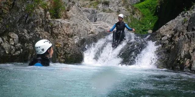 Deux personnes pratiquant le canyoning dans une cascade de montagne