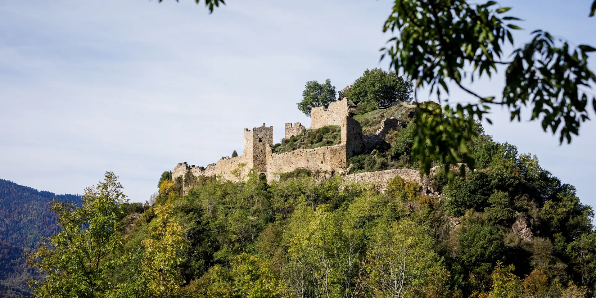 Château médiéval en pierre sur une colline verdoyante