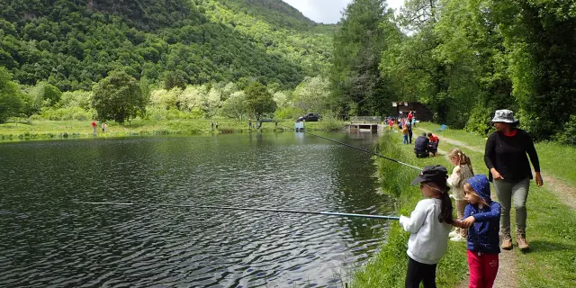 Enfants tenant des cannes à pêche au bord d'un lac