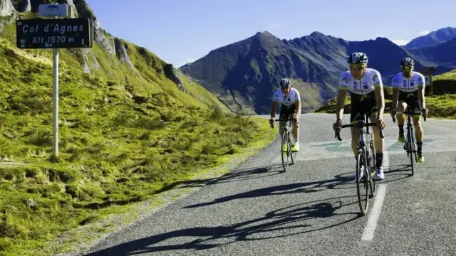 Trois cyclistes gravissent une route de montagne