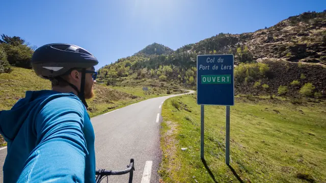 Un cycliste avec un vélo sur une route de montagne