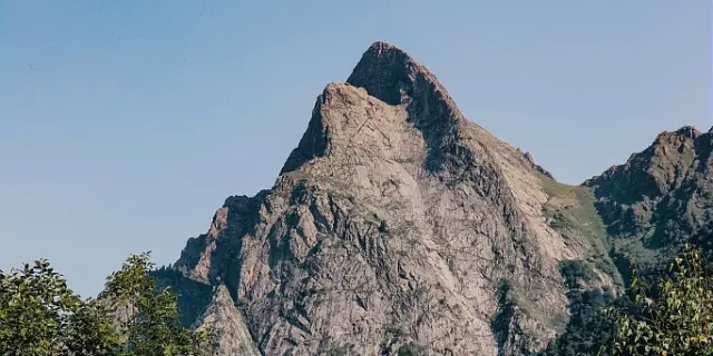 Une montagne rocheuse avec une forêt dense en contrebas