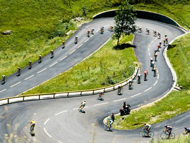 Cyclistes en compétition sur une route sinueuse en montagne