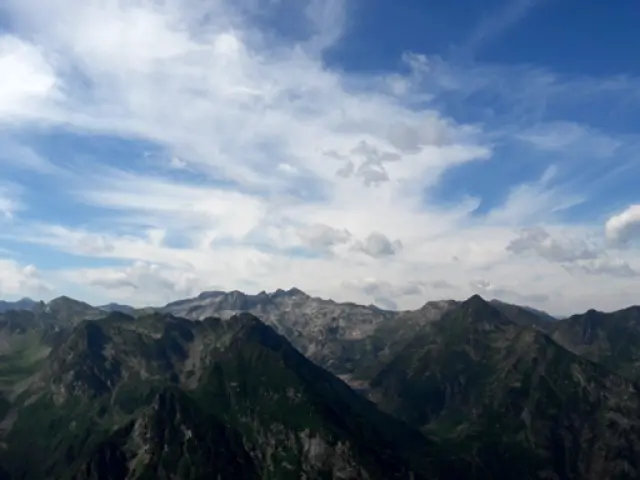Vue panoramique de montagnes avec des nuages blancs et un ciel bleu