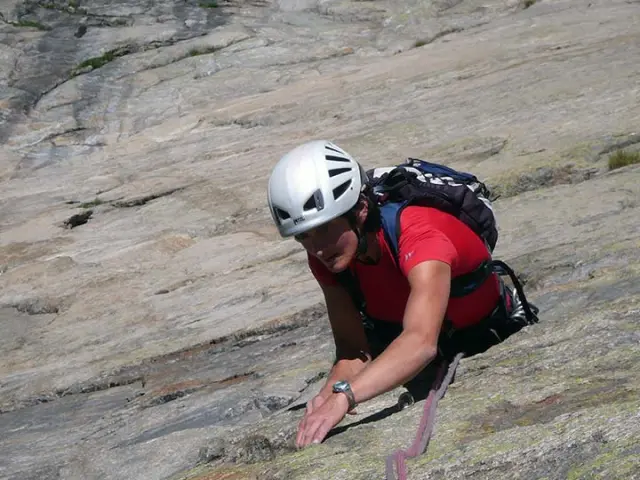 Un grimpeur en pleine ascension sur une paroi rocheuse