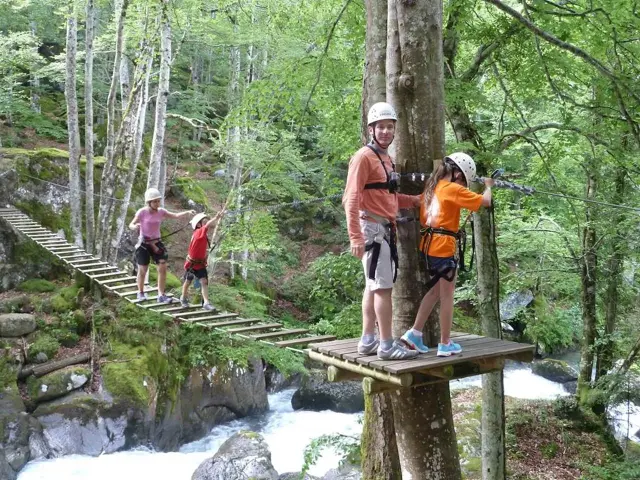 Groupe de personnes traversant une passerelle en bois dans une forêt