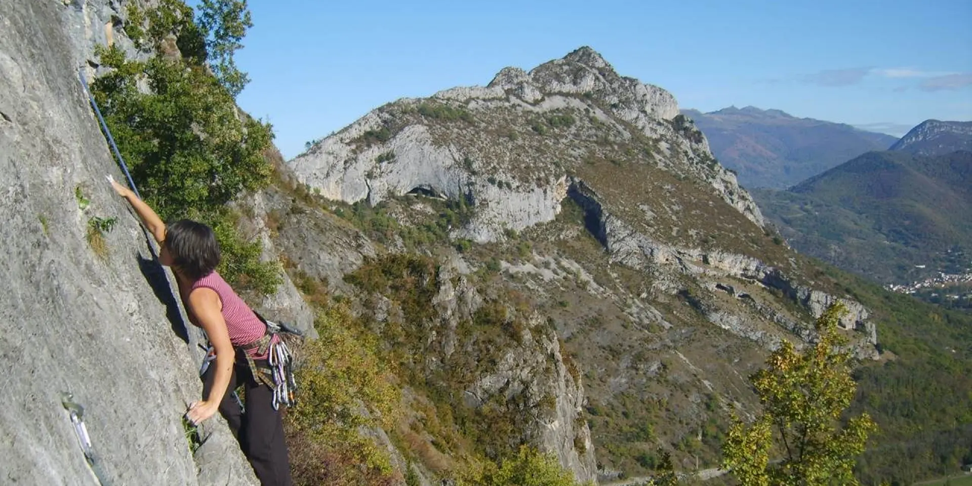Une personne en train d'escalader une paroi rocheuse en montagne