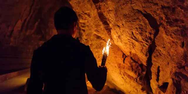 Personne explorant une grotte avec une torche