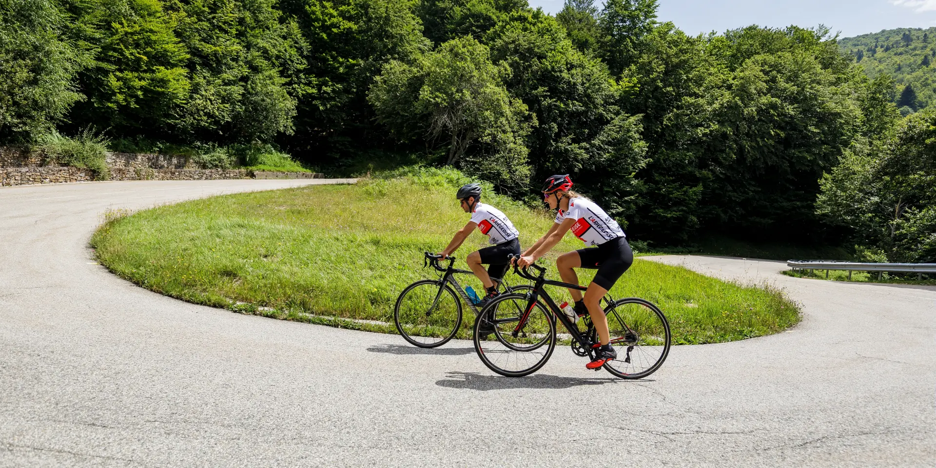 Two cyclists in sportswear on a country road