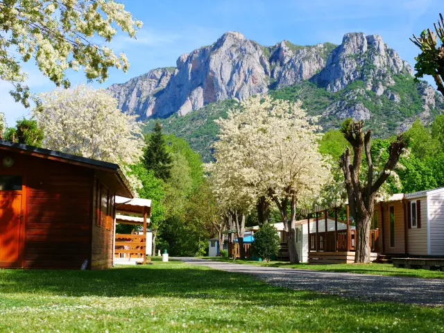 Wooden cabins in a vacation camp with mountains in the background