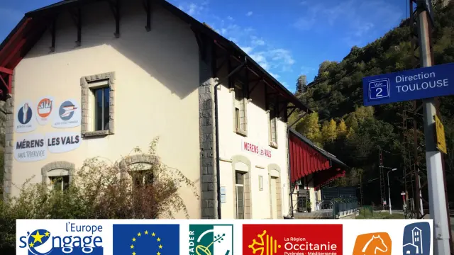 Building with several logos and a direction indicated by a sign