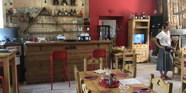 Interior of a bar with wooden tables, chairs, and a well-stocked bar