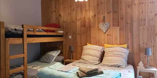 Bedroom with a double bed and a wooden bunk bed