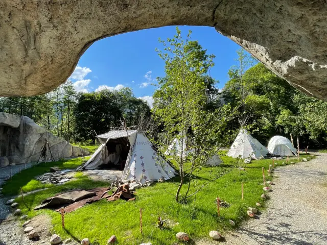 Campement avec tentes en forme de tipis sous des rochers