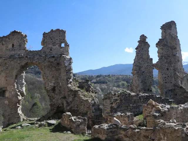 Ruines d'un château ancien avec des montagnes en arrière-plan