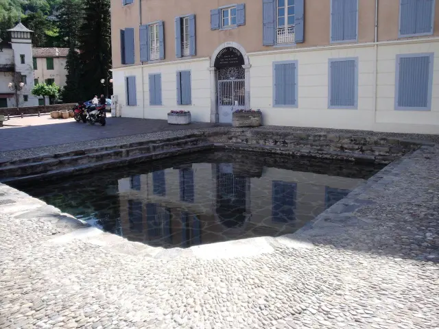 Cour d'un bâtiment historique avec une fontaine rectangulaire