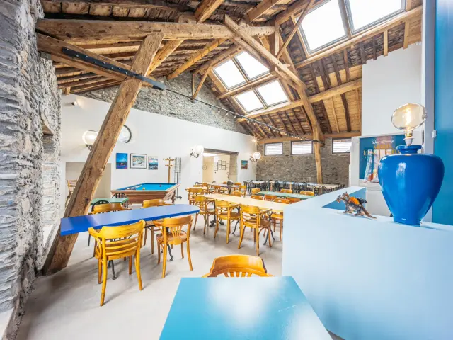 Dining room with wooden tables and chairs, stone walls and exposed beams