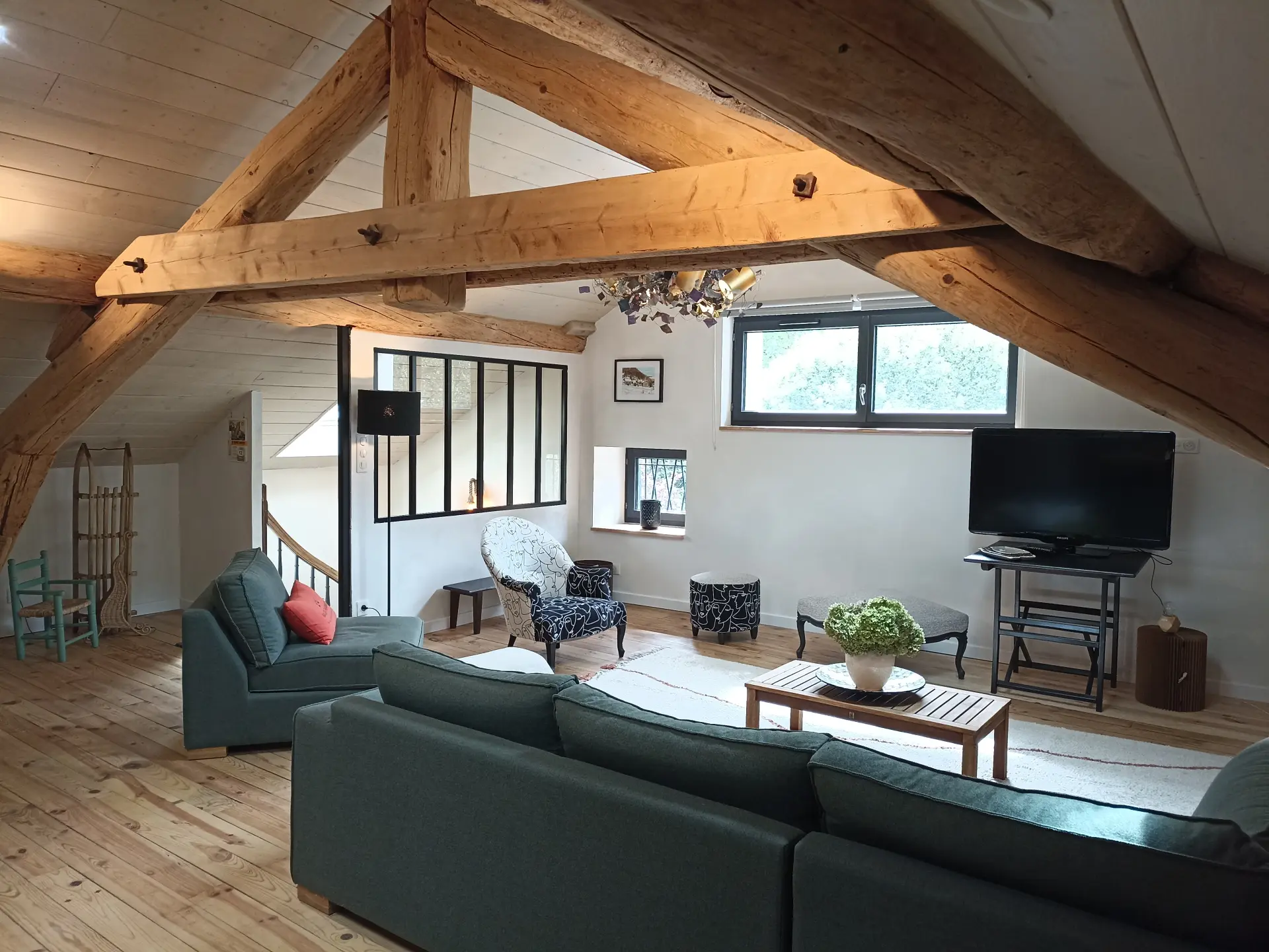 Living room with sofas, armchairs, television and large windows