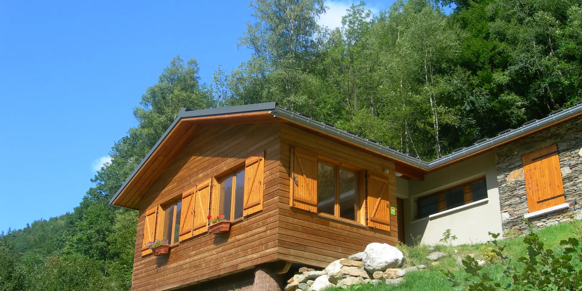 Gite d'étape avec des volets en bois sur une colline verdoyante