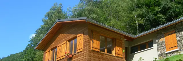 Gite d'étape avec des volets en bois sur une colline verdoyante