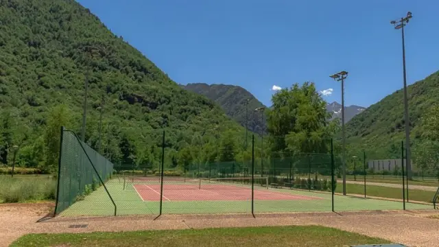 Terrains de tennis entourés de montagnes et d'arbres