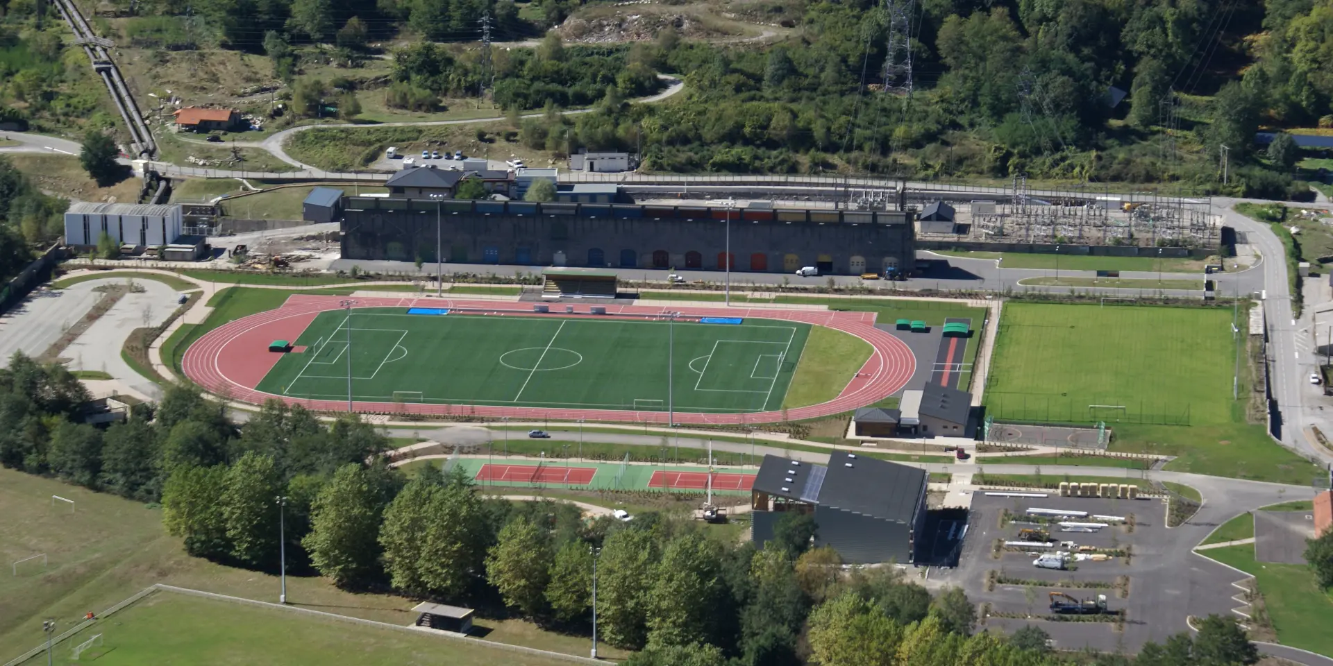 Vue aérienne d'un stade sportif avec des pistes d'athlétisme et des terrains de football