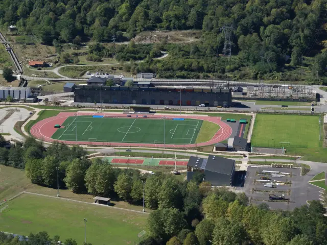 Vue aérienne d'un stade sportif avec des pistes d'athlétisme et des terrains de football