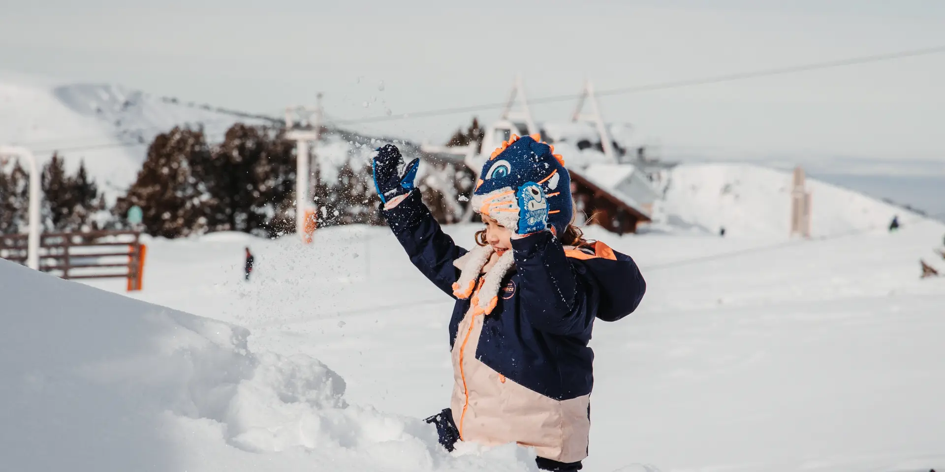 Child dressed warmly playing in the snow with gloves and a scarf