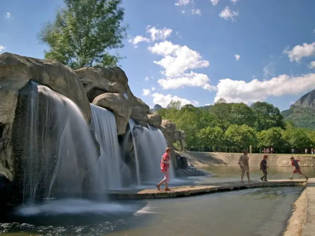 Children playing near a waterfall in a park