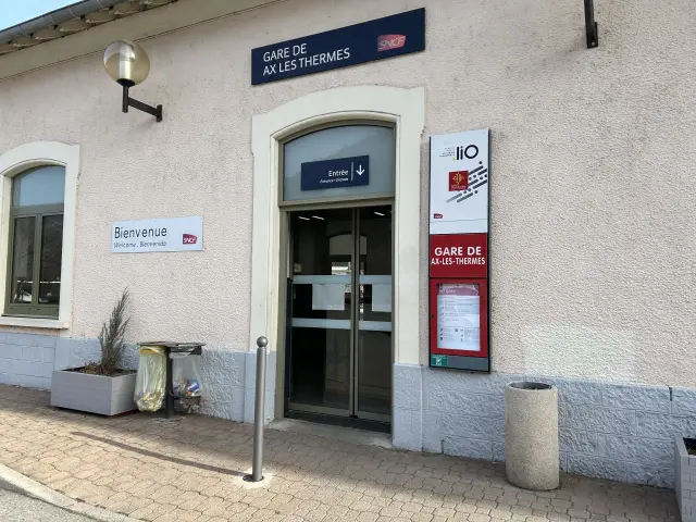 Entrée principale de la gare d'Ax-les-Thermes avec des panneaux d'information