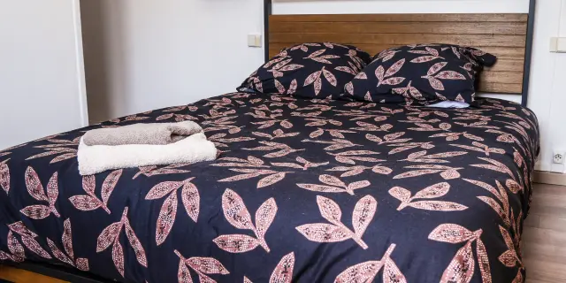 Lit avec une couverture à motifs floraux et deux oreillers assortis