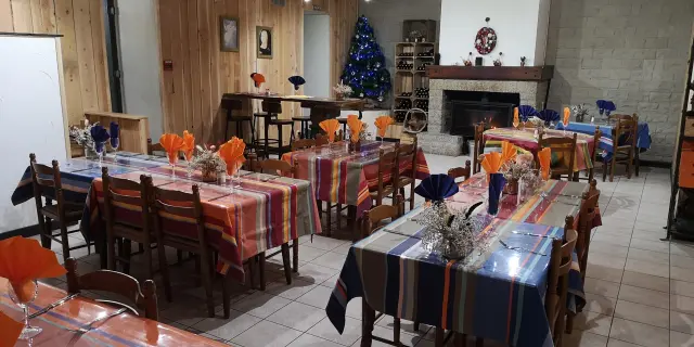 Salle à manger décorée pour les fêtes avec des tables couvertes de nappes colorées et des centres de table festifs
