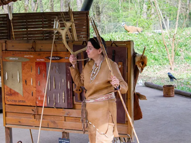 Une personne en tenue traditionnelle démonte des outils préhistoriques