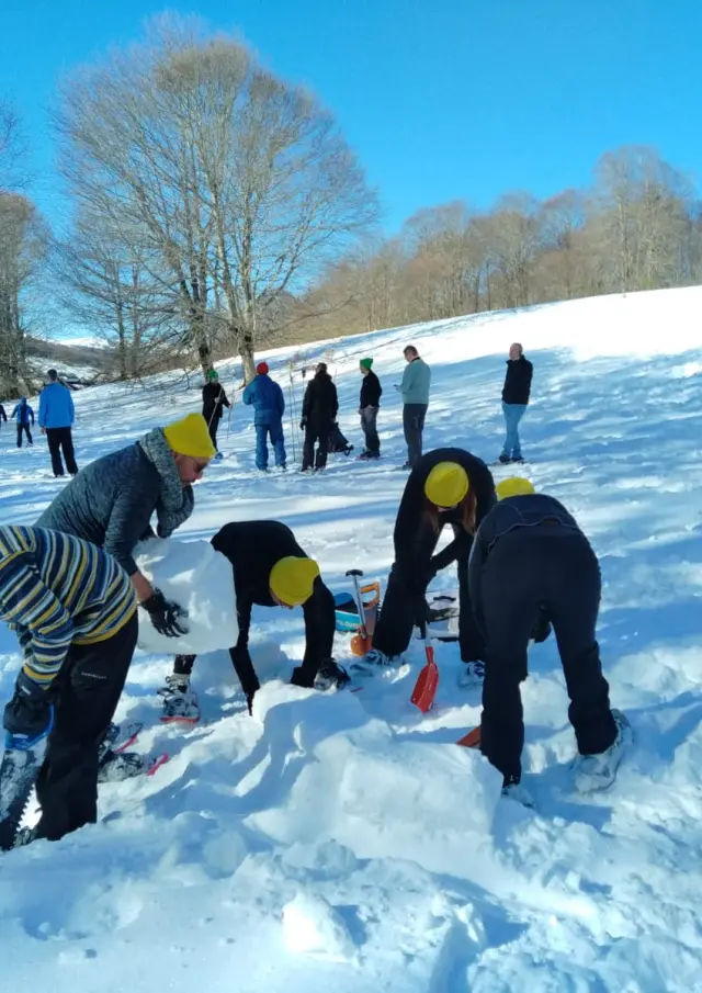 Quatre enfants portant des bonnets jaunes jouent dans la neige