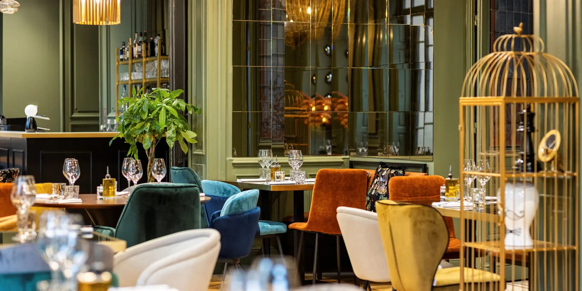 Intérieur d'un restaurant avec des chaises colorées, des tables bien dressées et des décorations lumineuses