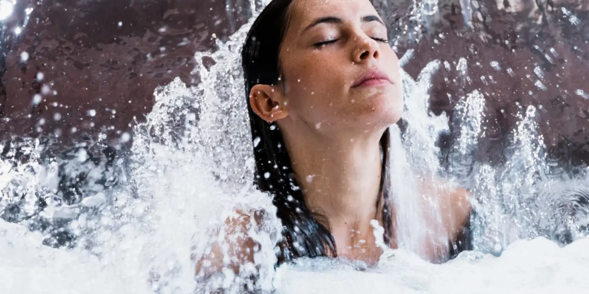 Woman relaxing under a waterfall