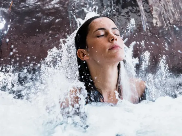 Woman relaxing under a waterfall